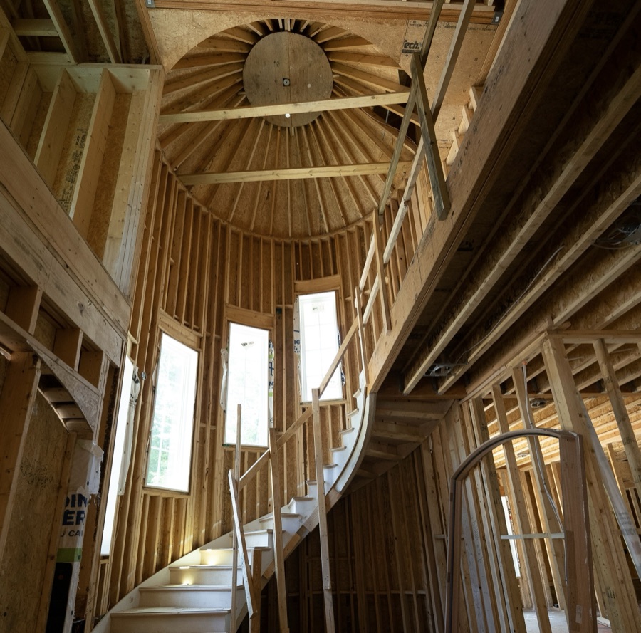 Custom home builder: timber-framed home interior with a curved staircase